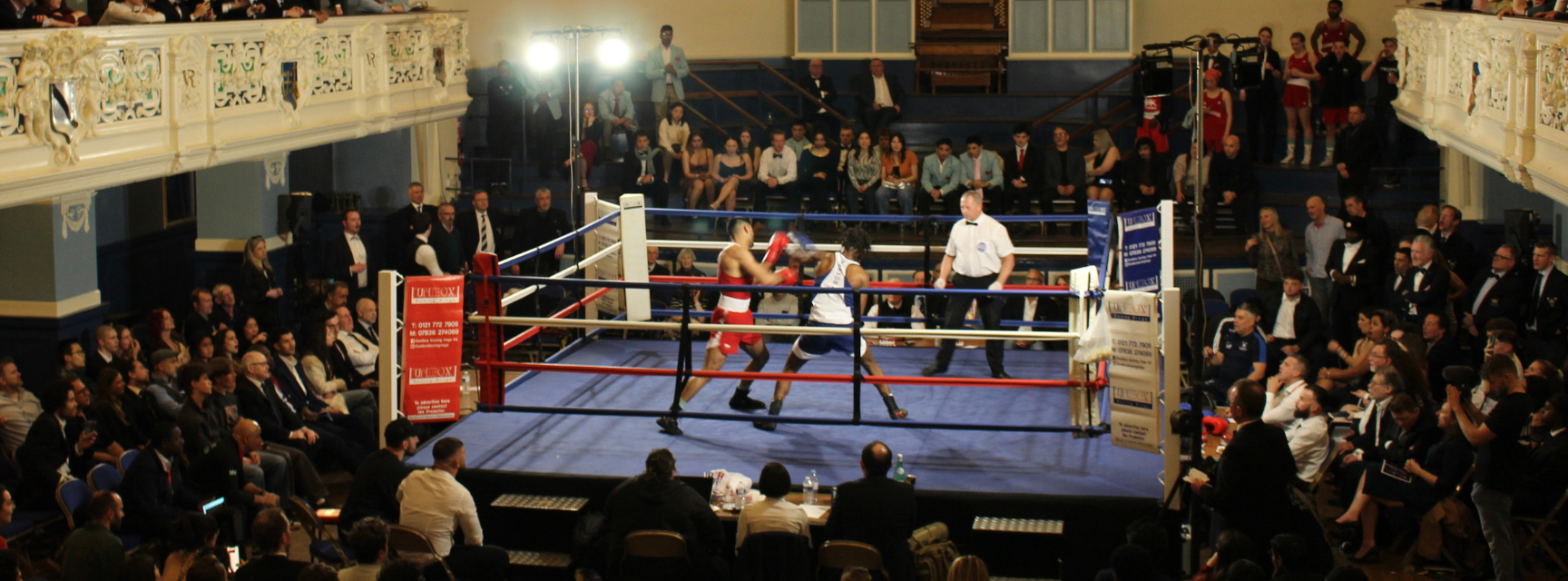 Two boxers competing in a boxing ring