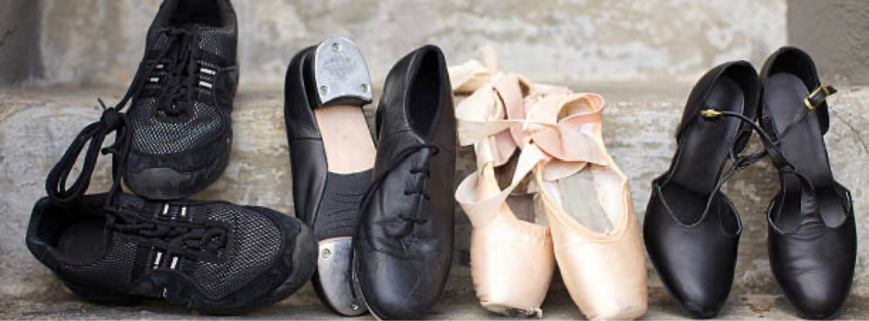 Dancing shoes of all different varieties laid out on a stone step
