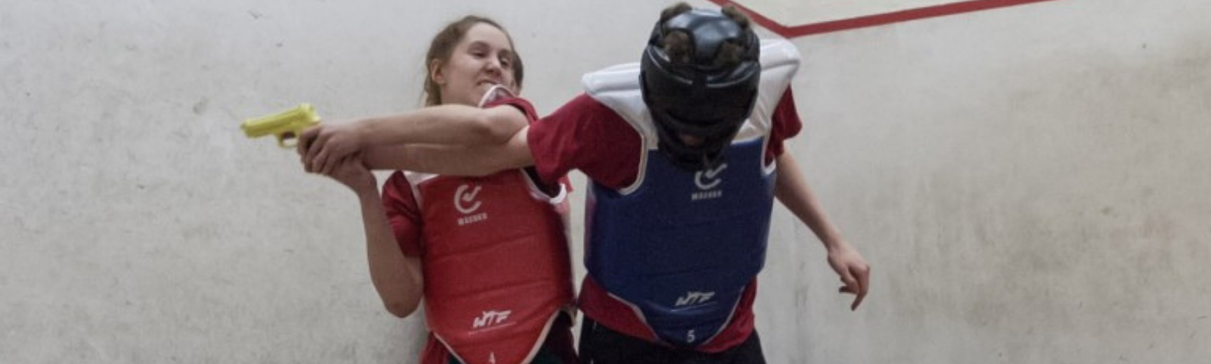 A women disarming an attacker in a training drill