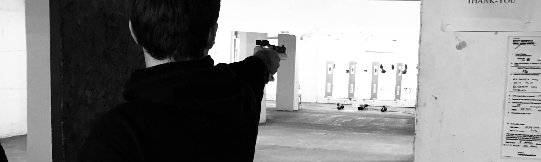 A person shooting towards a target with a pistol