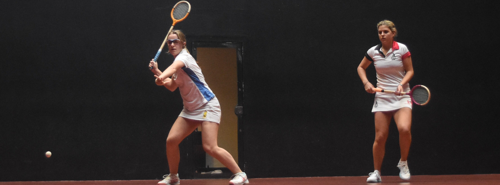 Two women playing Rackets against each other