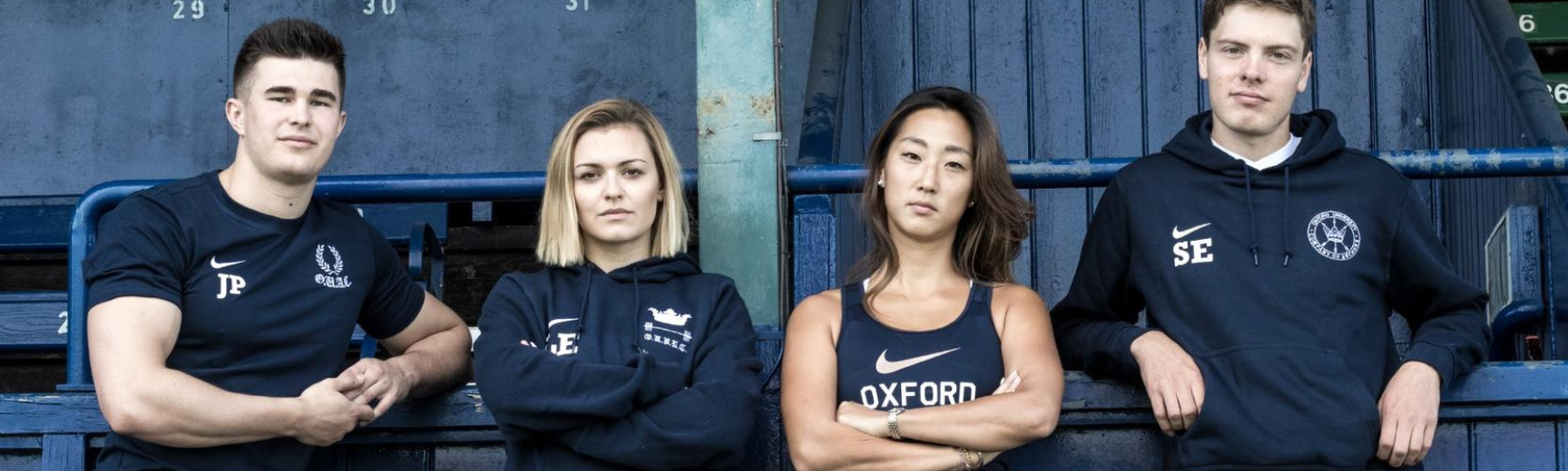 Four students posing in Nike branded leisure in Oxford Blue