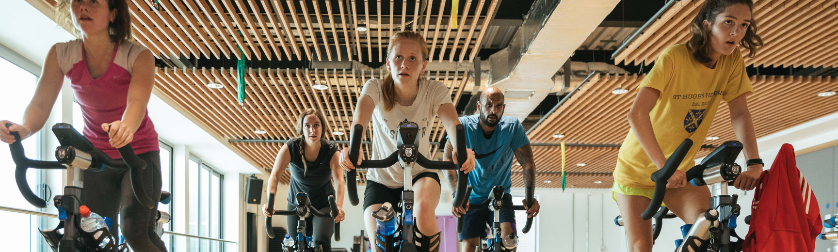 Five customers enjoying a Stages Indoor Cycling class