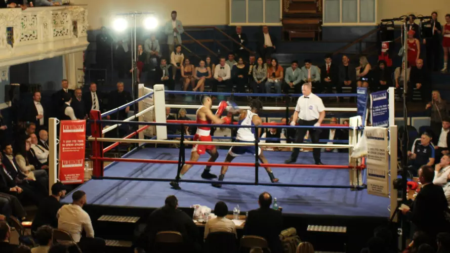 Two boxers competing in a boxing ring