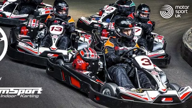Several karts racing around a corner alongside the OU Motor Drivers Club logo