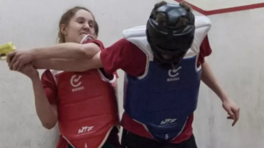 A women disarming an attacker in a training drill