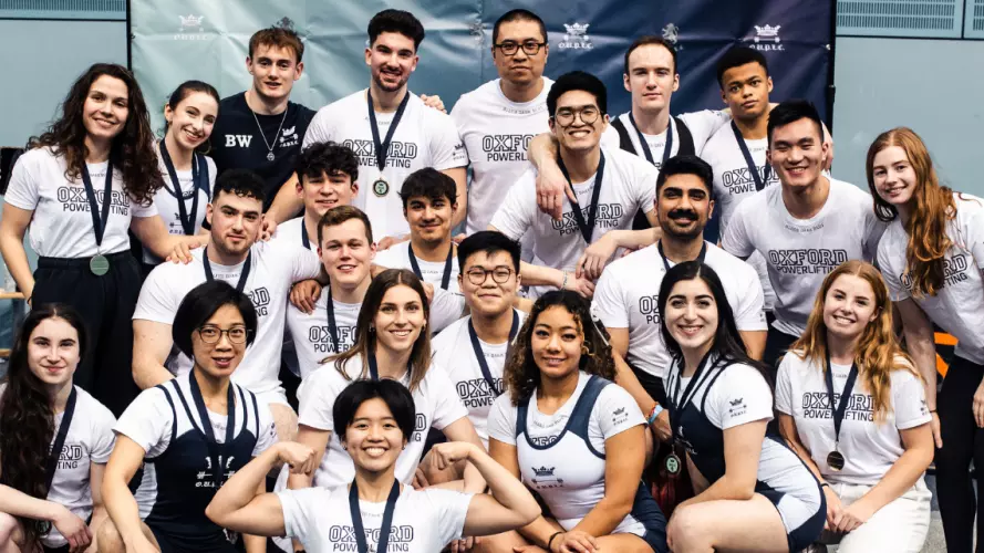 A group of powerlifters posing for a group photo after Varsity