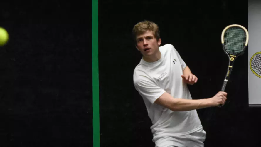 Two men playing real tennis with wooden rackets