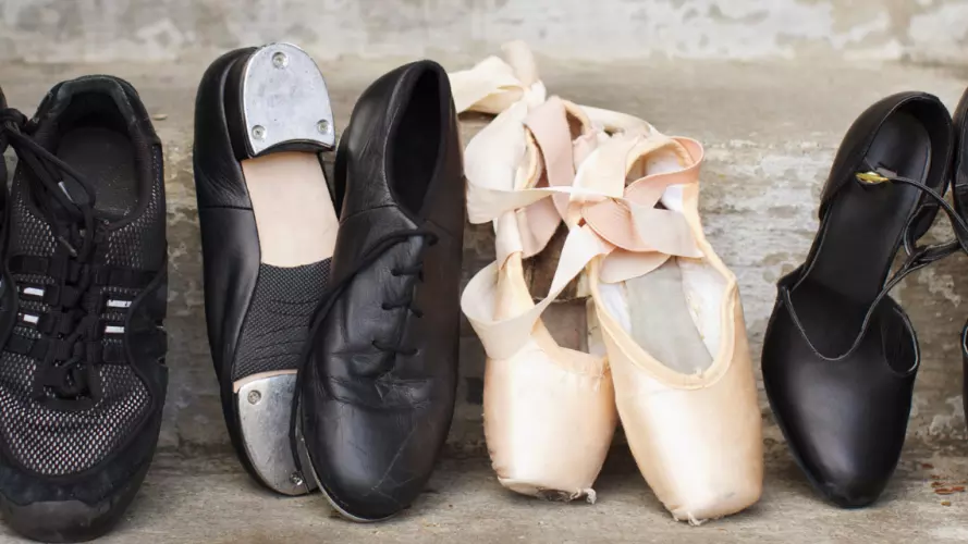 Dancing shoes of all different varieties laid out on a stone step